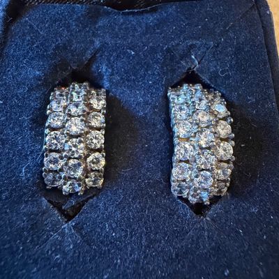 Sale Photo Thumbnail #23: Pair of wide diamond or cubic zirconia hoop earrings featuring three rows of round pave-set stones in a dark jewelry box.