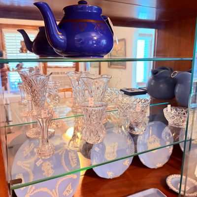 Sale Photo Thumbnail #17: Glassware and ceramics, featuring cobalt blue teapots , clear cut-glass vases and bowls, and light blue jasperware plates