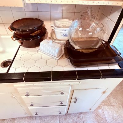 Sale Photo Thumbnail #65: Collection of vintage kitchenware including amber glass casserole dishes, CorningWare Blue Cornflower baking dishes, and a ceramic butter dish.