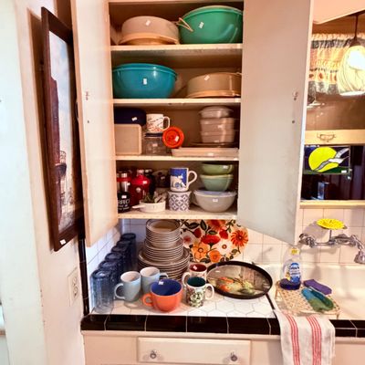 Sale Photo Thumbnail #63: Kitchen cabinet filled with vintage Tupperware, mixing bowls, dishware and glassware.