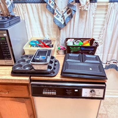Sale Photo Thumbnail #70: Collection of kitchen items including muffin tins, loaf pans, plastic serving trays, and organizers filled with utensils