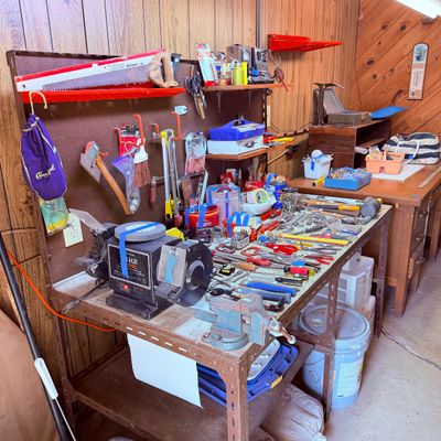 Sale Photo Thumbnail #96: Workshop workbench setup featuring a electric bench grinder, bench vise, hand saws, and assorted hand tools.