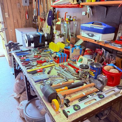 Sale Photo Thumbnail #100: assorted hand tools, including hammers, wrenches, pliers, screwdrivers, a bench grinder, and a spirit level.