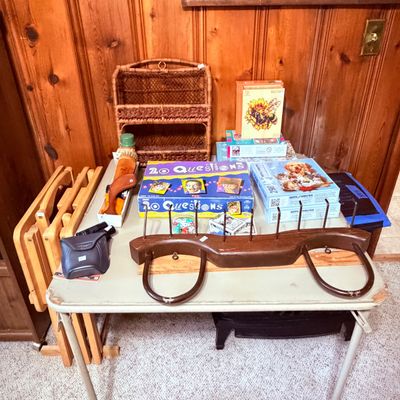 Sale Photo Thumbnail #73: Board games, jigsaw puzzles, a vintage wicker shelf, and a wooden coat or harness rack.