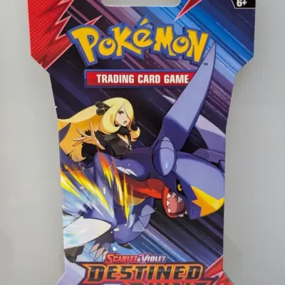 Sale Photo Thumbnail #568: Sealed Pokémon Trading Card Game Scarlet & Violet Destined Rivals sleeved booster pack featuring Cynthia and Garchomp artwork.