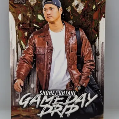 Sale Photo Thumbnail #269: Topps Shohei Ohtani "Gameday Drip" trading card featuring a full-length photo of the baseball star in street clothes against a patterned background.