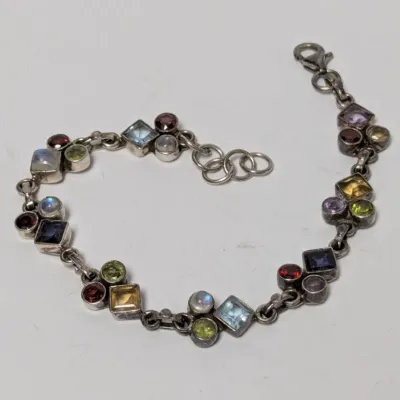 Sale Photo Thumbnail #969: Sterling silver link bracelet set with bezel-cut multi-color gemstones, including peridot, garnet, citrine, amethyst, and moonstone.