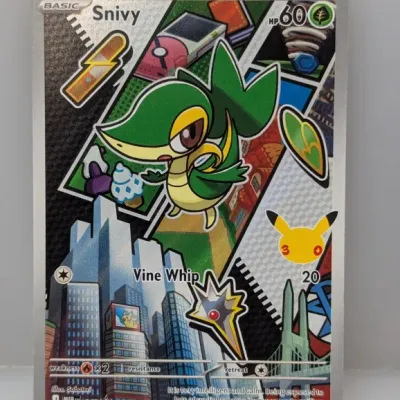 Sale Photo Thumbnail #637: Pokémon Trading Card Game Snivy full-art promo card, featuring colorful comic-style panel artwork and the 25th anniversary Pikachu stamp.