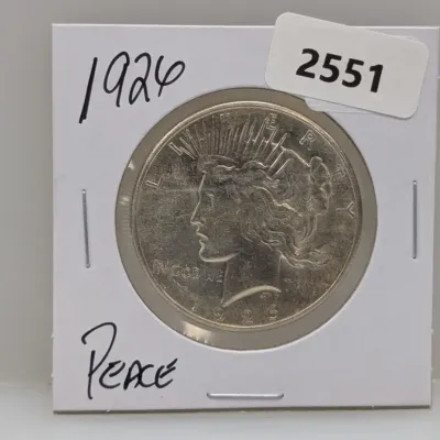Sale Photo Thumbnail #1042: 1926 Peace silver dollar coin in a protective cardboard flip holder.