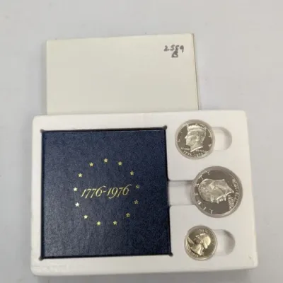 Sale Photo Thumbnail #1052: 1976 United States Bicentennial silver proof 3-coin set, housed in its original blue display case and white outer sleeve.