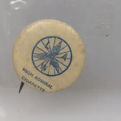 Sale Photo Thumbnail #101: Vintage High Admiral Cigarette celluloid pinback button, featuring a blue compass rose graphic on a cream-colored background.