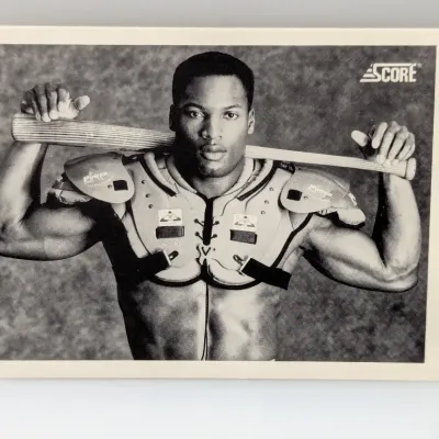 Sale Photo Thumbnail #910: 1990 Score Bo Jackson #697 black-and-white trading card featuring him wearing shoulder pads and holding a baseball bat.