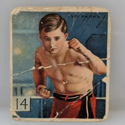 Sale Photo Thumbnail #405: Vintage early 20th-century boxing trading card featuring Wm. Papke, showing significant creasing, wear, and surface damage.