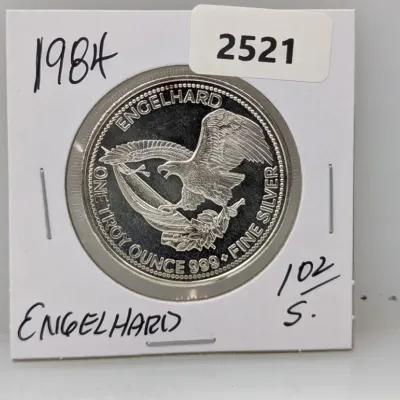 Sale Photo Thumbnail #1012: 1984 Engelhard 1 troy ounce .999 fine silver round featuring an American eagle design, presented in a protective cardboard flip holder.
