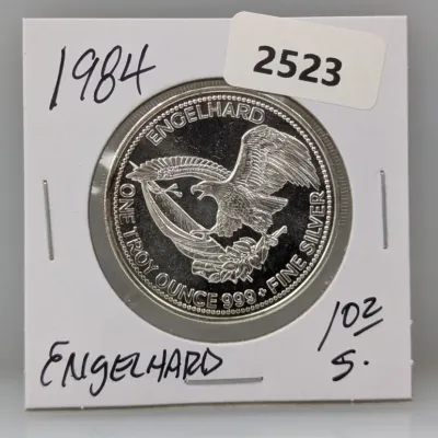 Sale Photo Thumbnail #1014: 1984 Engelhard 1 troy ounce .999 fine silver round featuring an American eagle motif, packaged in a protective cardboard flip.