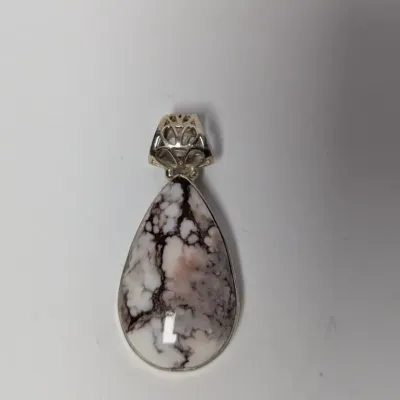 Sale Photo Thumbnail #986: Teardrop-shaped White Buffalo turquoise pendant set in sterling silver with an ornate filigree bail.