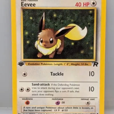 Sale Photo Thumbnail #463: 1st Edition Eevee Pokémon trading card (#55/82) from the Team Rocket set, released by Wizards of the Coast in 2000.