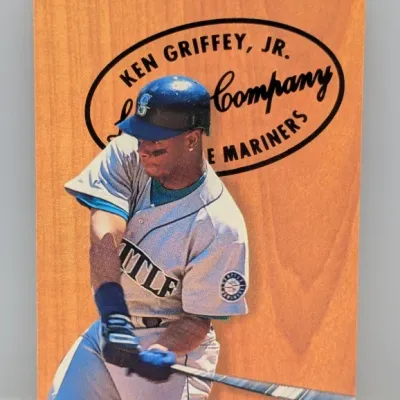 Sale Photo Thumbnail #223: 1994 Fleer Ken Griffey Jr. "Lumber Company" insert trading card, featuring the Seattle Mariners star mid-swing against a faux woodgrain backdrop.