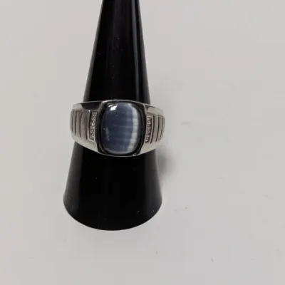 Sale Photo Thumbnail #947: Men's sterling silver or white gold ring featuring a blue cat's eye cabochon stone flanked by small diamond accents.