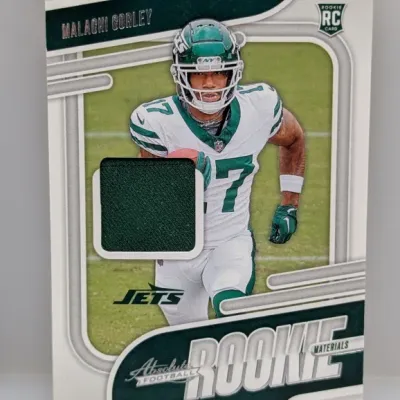 Sale Photo Thumbnail #295: Malachi Corley Panini Absolute Football rookie materials card featuring an embedded green jersey swatch patch.