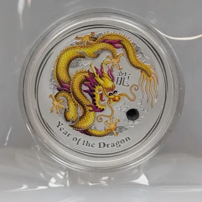 Sale Photo Thumbnail #998: Perth Mint Year of the Dragon colorized silver coin in a clear protective plastic capsule and sleeve.