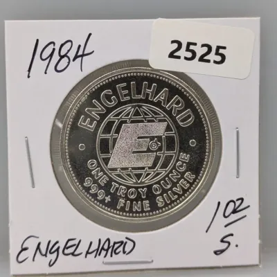 Sale Photo Thumbnail #1016: 1984 Engelhard one troy ounce 999+ fine silver round, housed in a cardboard coin flip holder.