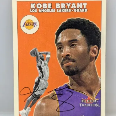 Sale Photo Thumbnail #367: Autographed Kobe Bryant Fleer Tradition basketball card, depicting the Los Angeles Lakers guard with printed signature overlay.