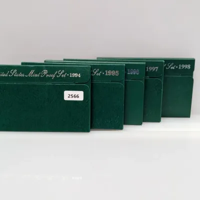 Sale Photo Thumbnail #1061: Five United States Mint Proof Sets in original green packaging, spanning consecutive years from 1994 through 1998.