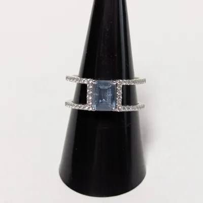 Sale Photo Thumbnail #953: Contemporary sterling silver or white gold ring featuring an emerald-cut light blue stone flanked by clear pave accent bands.