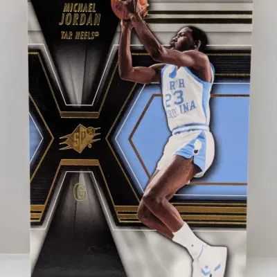 Sale Photo Thumbnail #914: Michael Jordan SPx North Carolina Tar Heels trading card featuring a die-cut style design with gold foil accents.