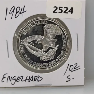 Sale Photo Thumbnail #1015: 1984 Engelhard 1 troy ounce .999 fine silver round featuring an American eagle design, housed in a cardboard flip holder.