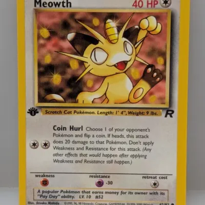 Sale Photo Thumbnail #799: 1st Edition Meowth Pokémon trading card (62/82) from the Team Rocket expansion set, produced by Wizards of the Coast circa 2000.