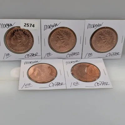 Sale Photo Thumbnail #1070: Set of five 1 oz copper rounds featuring the Morgan dollar design, individually housed in cardboard coin flips.