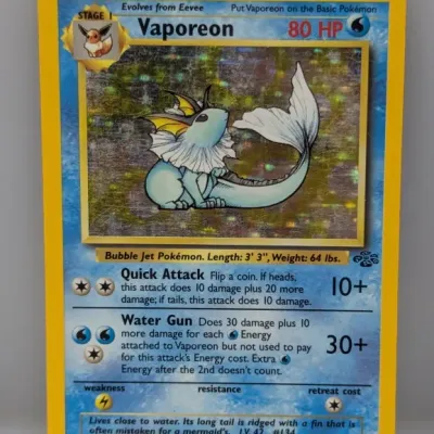Sale Photo Thumbnail #250: Vintage 1999 Pokémon Jungle Set holographic Vaporeon card (12/64). The card shows noticeable surface scratching on the foil art window.