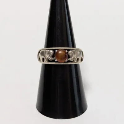 Sale Photo Thumbnail #966: Sterling silver elephant ring set with a round, reddish-brown gemstone cabochon.