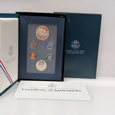 Sale Photo Thumbnail #1056: 1990 United States Mint Prestige Set featuring the Eisenhower Centennial silver dollar, housed in its original velvet display case with outer box and Certificate of Authenticity.