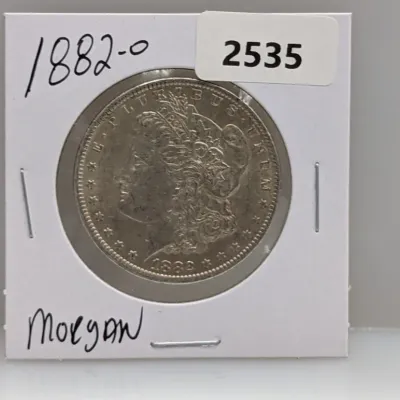 Sale Photo Thumbnail #1026: 1882-O Morgan silver dollar stored in a cardboard coin flip holder.
