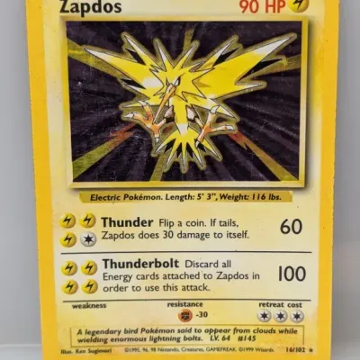 Sale Photo Thumbnail #74: Vintage 1999 Wizards of the Coast Pokémon Base Set holographic Zapdos trading card (16/102). The card shows moderate play wear along the edges and corners with light surface scratching on the foil.