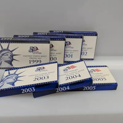 Sale Photo Thumbnail #1063: Collection of seven United States Mint Proof Sets in original government packaging, dating from 1999 through 2005.