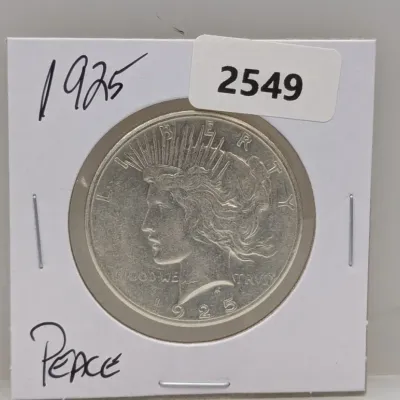 Sale Photo Thumbnail #1040: 1925 Peace silver dollar coin in a protective cardboard flip.
