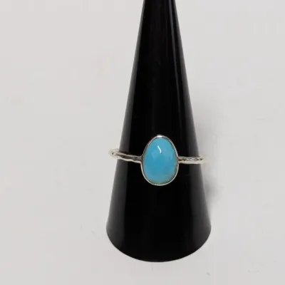 Sale Photo Thumbnail #959: Simple sterling silver ring featuring a smooth, oval turquoise cabochon on a textured band.