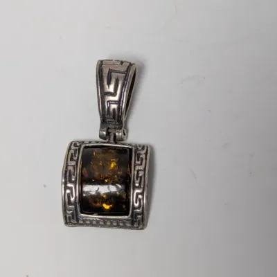 Sale Photo Thumbnail #977: Sterling silver and amber pendant featuring a Greek key pattern frame and wide textured bail.