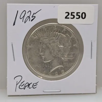 Sale Photo Thumbnail #1041: 1925 Peace Silver Dollar coin stored in a protective cardboard flip holder.