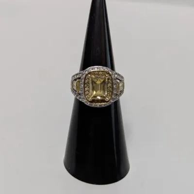 Sale Photo Thumbnail #950: Contemporary yellow and white stone halo statement ring displayed on a black cone ring stand.
