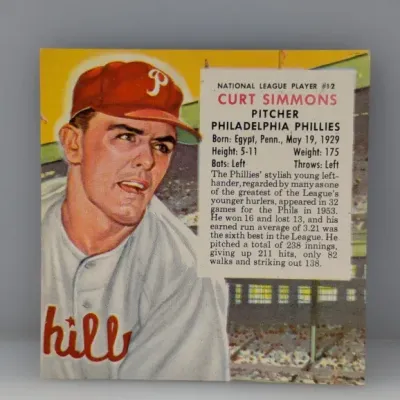 Sale Photo Thumbnail #495: 1954 Topps #12 Curt Simmons baseball card, featuring a color portrait of the Philadelphia Phillies pitcher alongside player statistics.