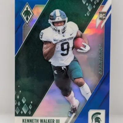 Sale Photo Thumbnail #716: 2022 Panini Phoenix Kenneth Walker III Michigan State Spartans rookie trading card with a blue holographic finish.