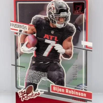 Sale Photo Thumbnail #505: 2023 Donruss Clearly Donruss 'The Rookies' Bijan Robinson clear acetate football trading card, serial numbered 033/100.