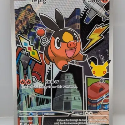 Sale Photo Thumbnail #648: Tepig full-art promo Pokémon trading card featuring a collage illustration style and a 30th Anniversary Pikachu logo.