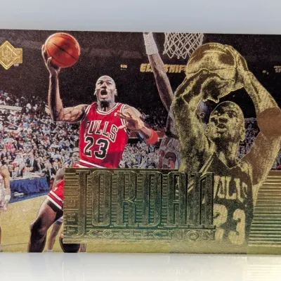 Sale Photo Thumbnail #445: 1990s Upper Deck The Jordan Collection Michael Jordan basketball trading card featuring textured gold foil detailing.