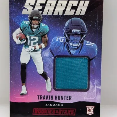 Sale Photo Thumbnail #594: Panini Rookies & Stars Star Search Travis Hunter rookie card with an embedded teal jersey patch.